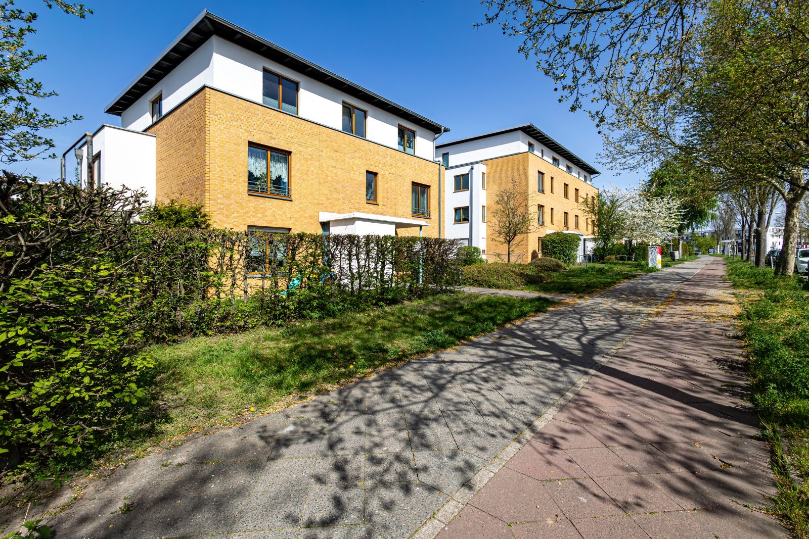 Grüneck Berlin — Wohnanlage mit gelber Klinkerfassade und Weg entlang der Gebäude